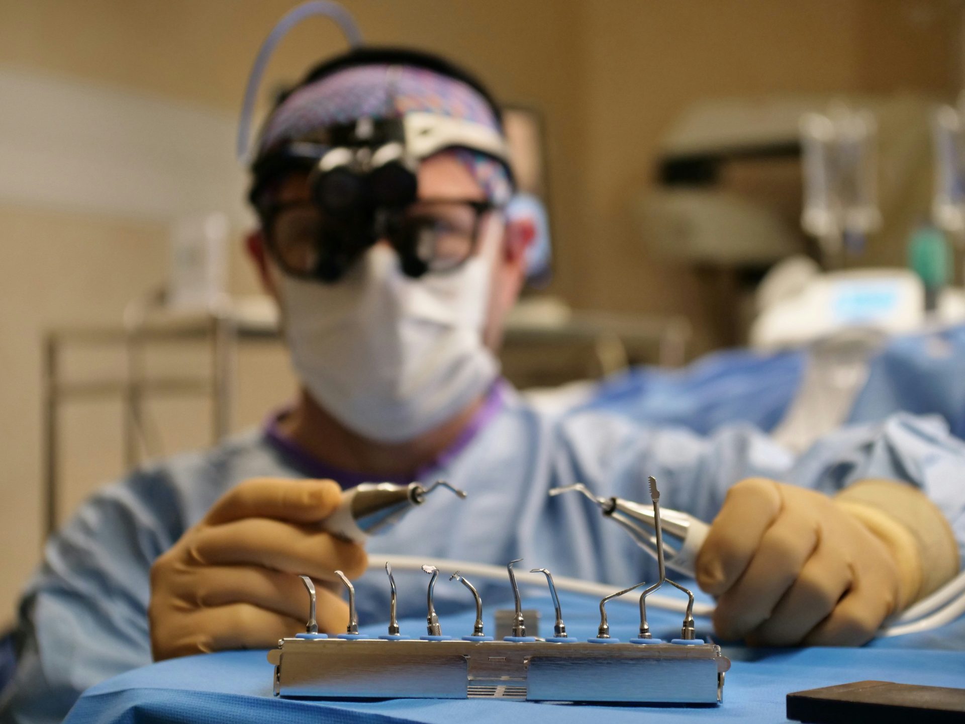 Surgeon prepares tools in the operating room.